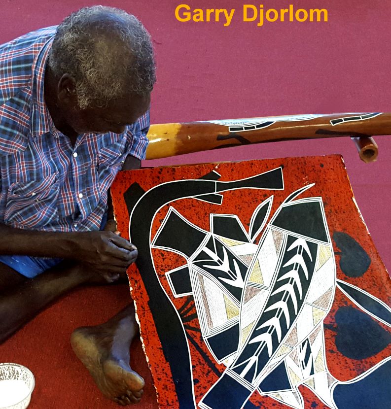 photo of aboriginal artist Djardi holding one of his paintings 